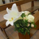 composizione con giglio e rose per panche invitati