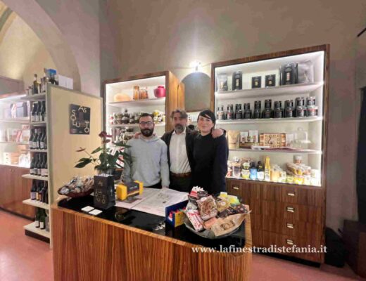 Interno dell'Antica Corsetteria Arezzo con arredi d'epoca e prodotti gastronomici di lusso.