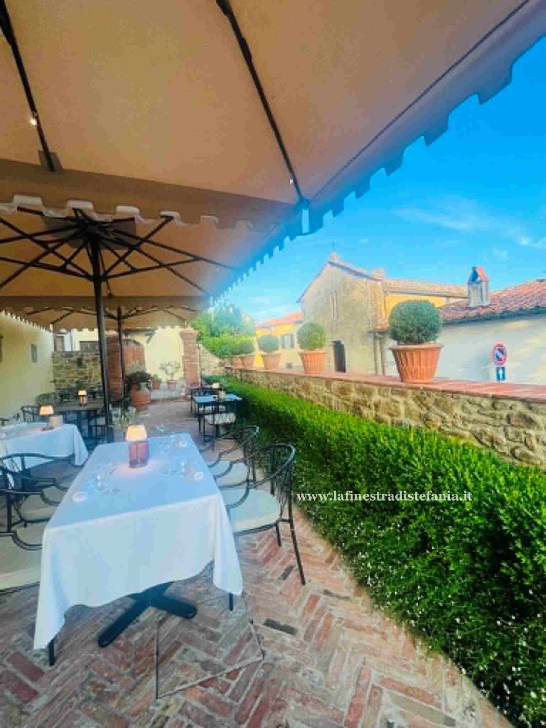 Prospetti ed interni storici del boutique hotel Palazzo Tiglio a San Pancrazio, Toscana, con tavoli allestiti all'aperto per la stagione 2026